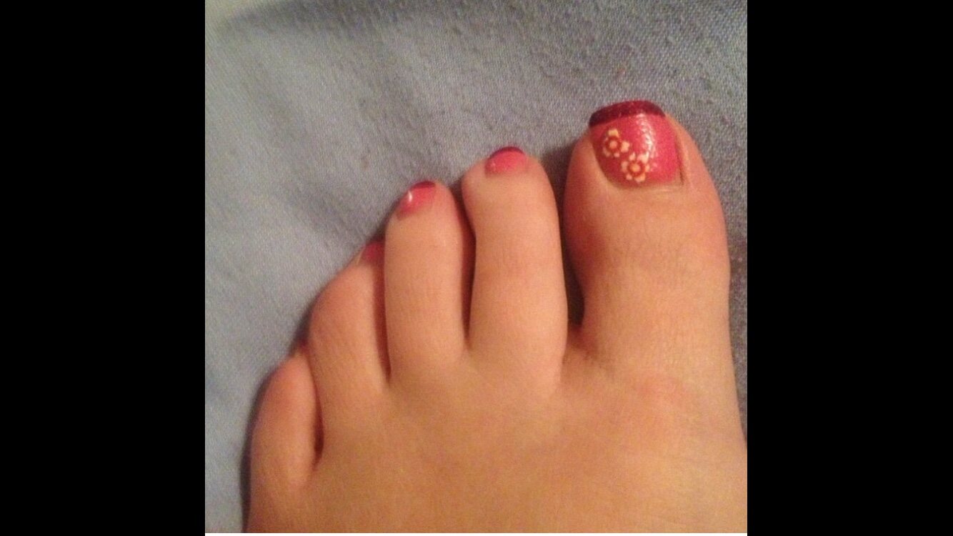 Red pedicure with gold accent detail